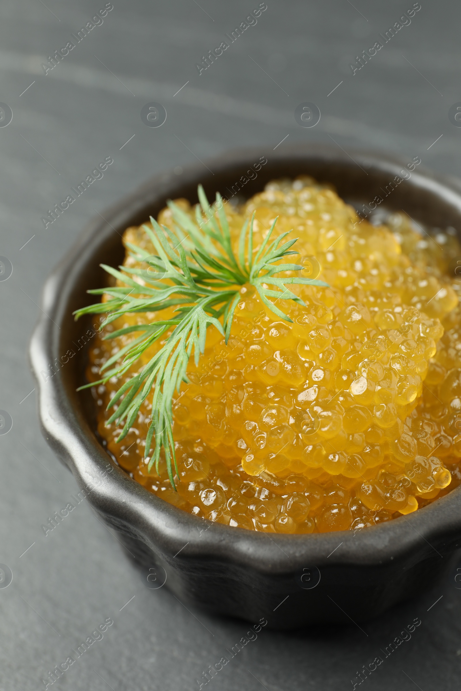 Photo of Fresh pike caviar in bowl on black table, closeup