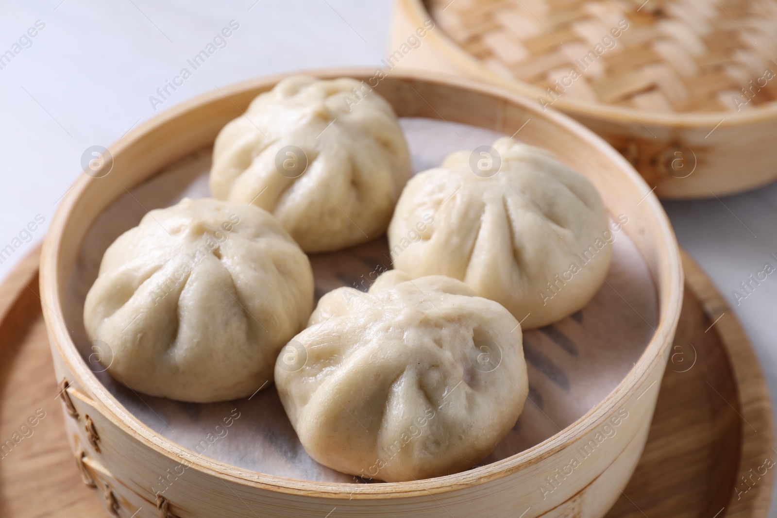 Photo of Delicious bao buns (baozi) on light table, closeup