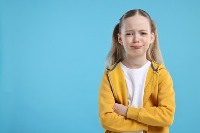 Photo of Portrait of sad girl on light blue background, space for text