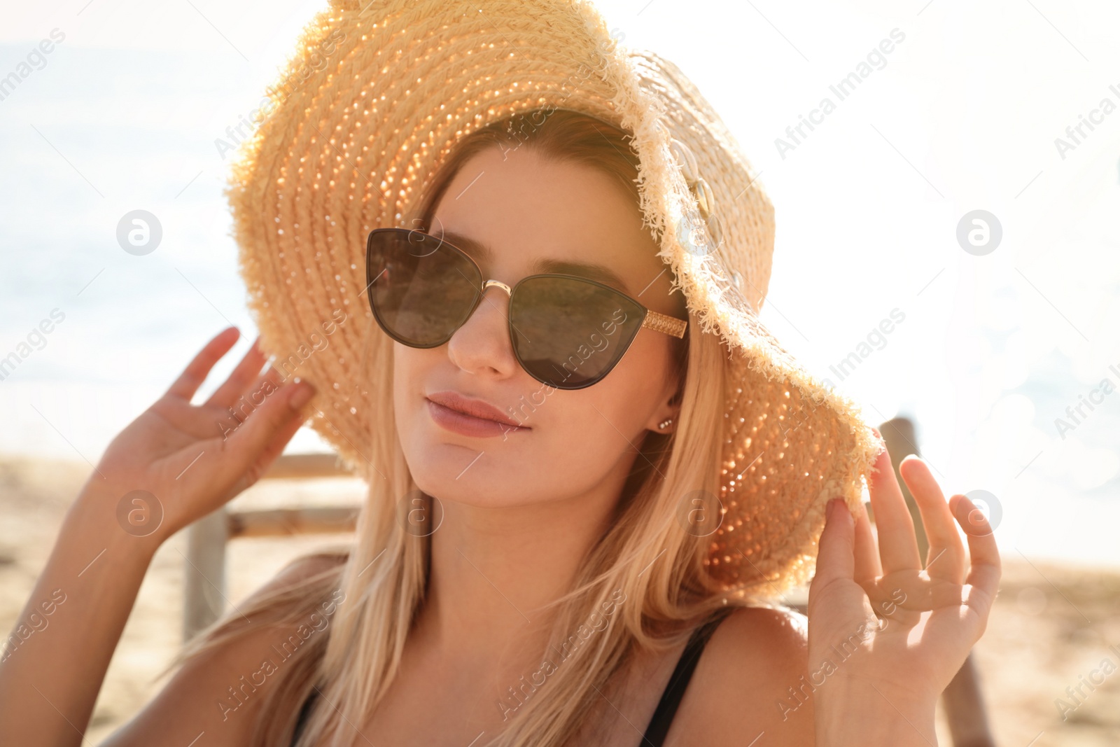 Photo of Beautiful woman wearing sunglasses outdoors on sunny day