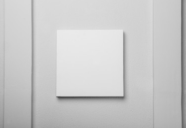 Photo of Blank canvas on white wall. Space for design