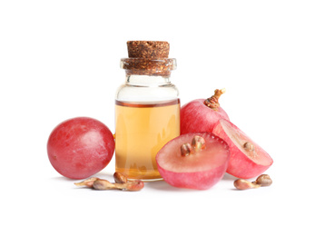 Organic red grapes, seeds and bottle of natural essential oil on white background