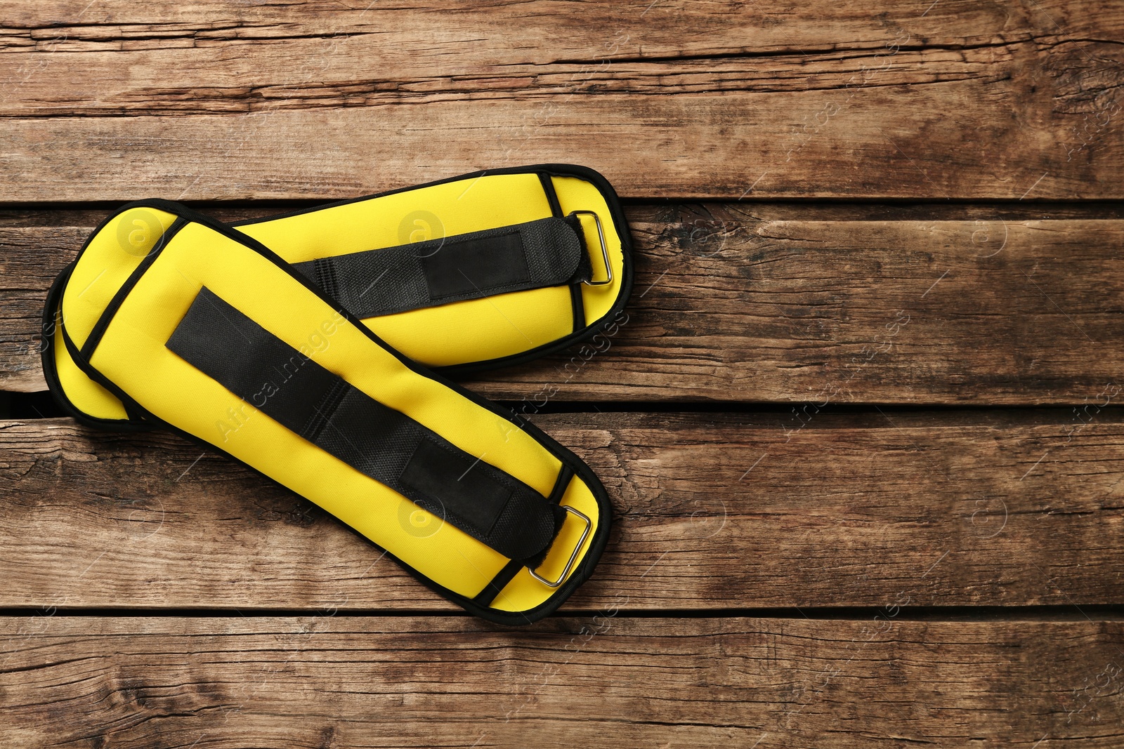 Photo of Yellow weighting agents on wooden table, flat lay. Space for text