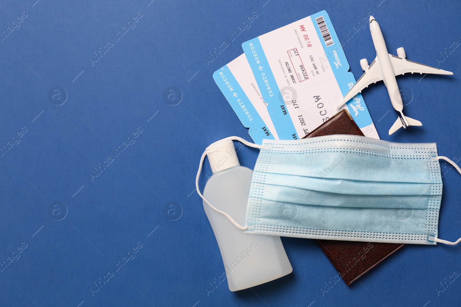 Photo of Flat lay composition with passport and protective mask on blue background, space for text. Travel during quarantine