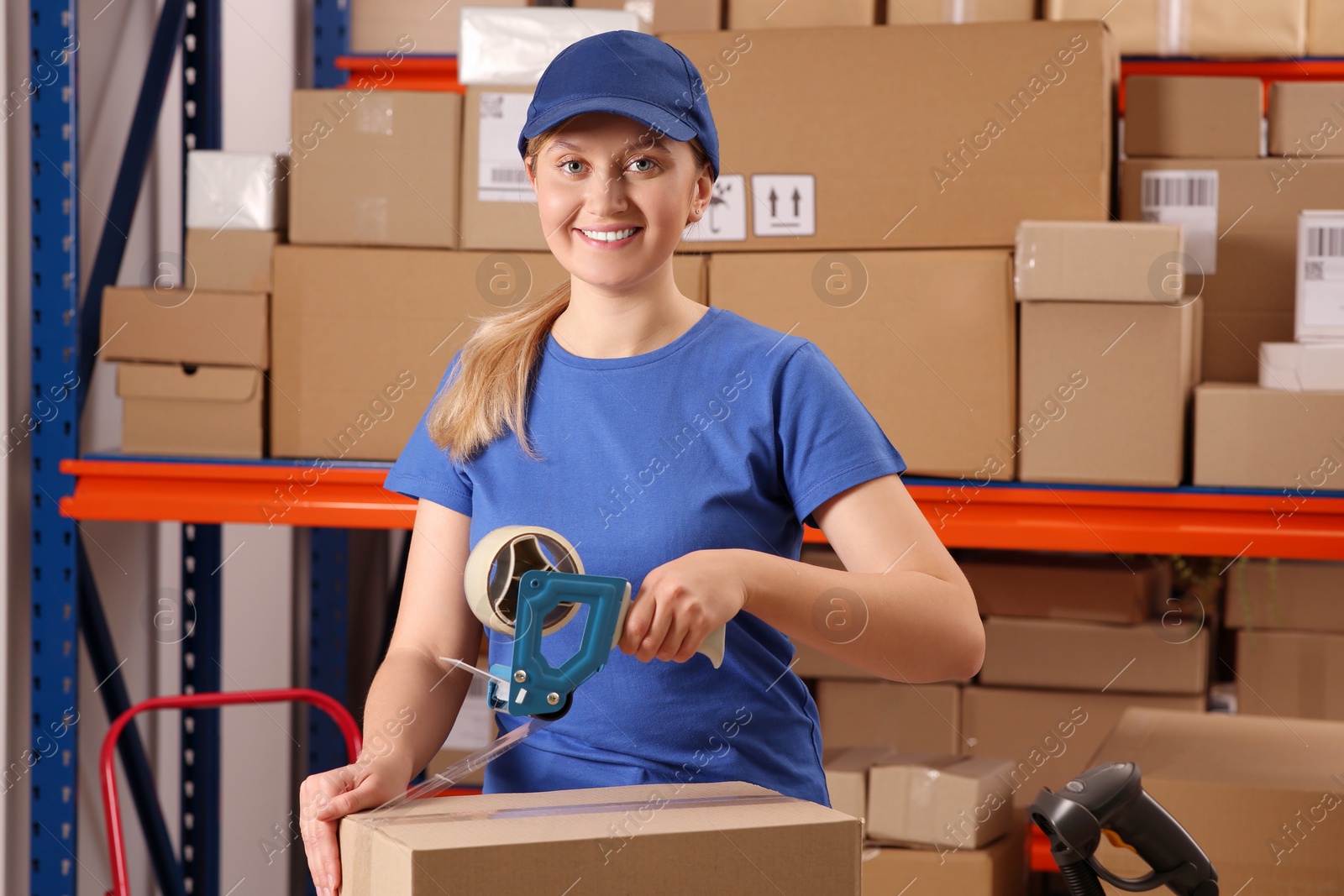 Photo of Post office worker packing parcel near rack indoors