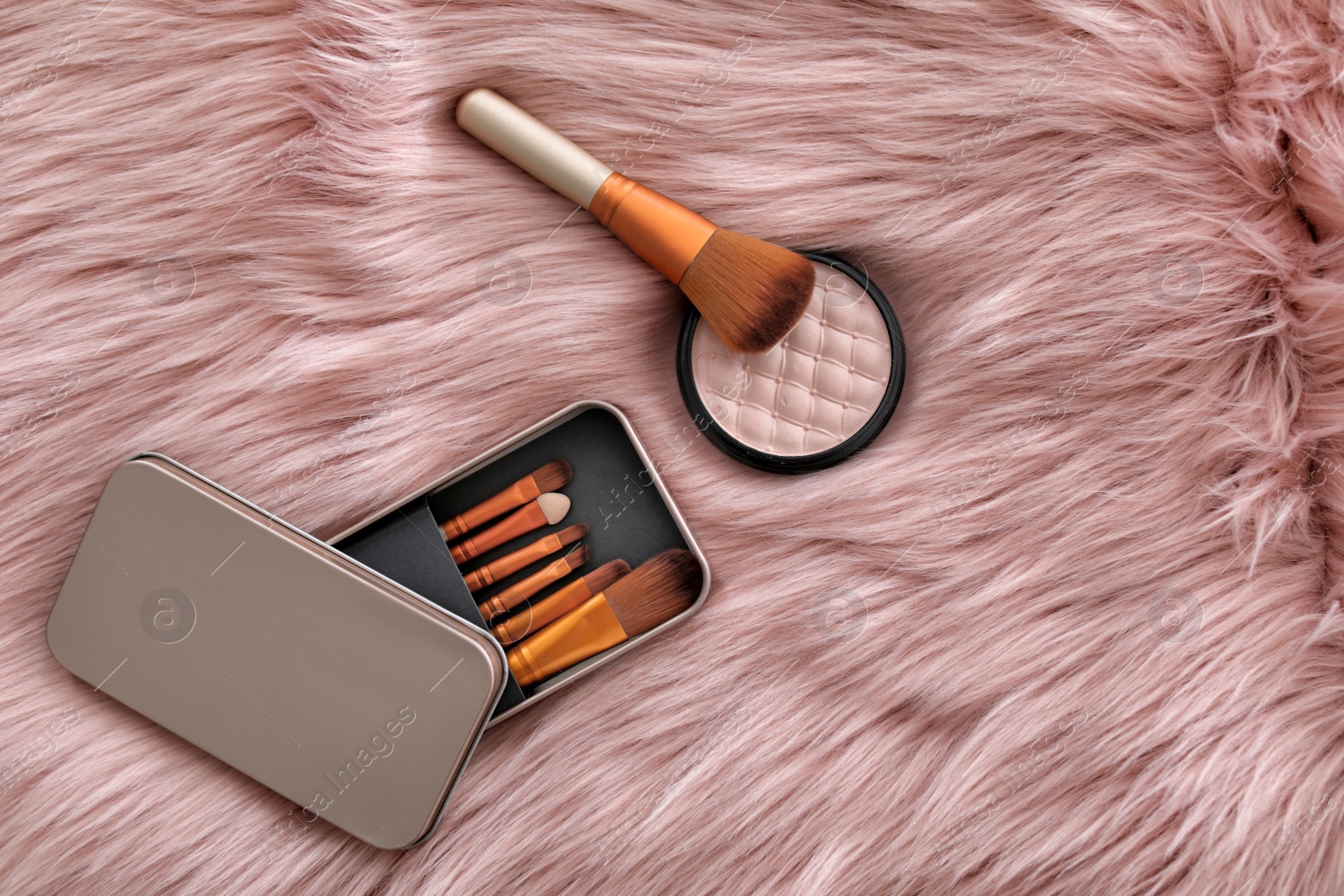 Photo of Flat lay composition with makeup brushes and powder on faux fur