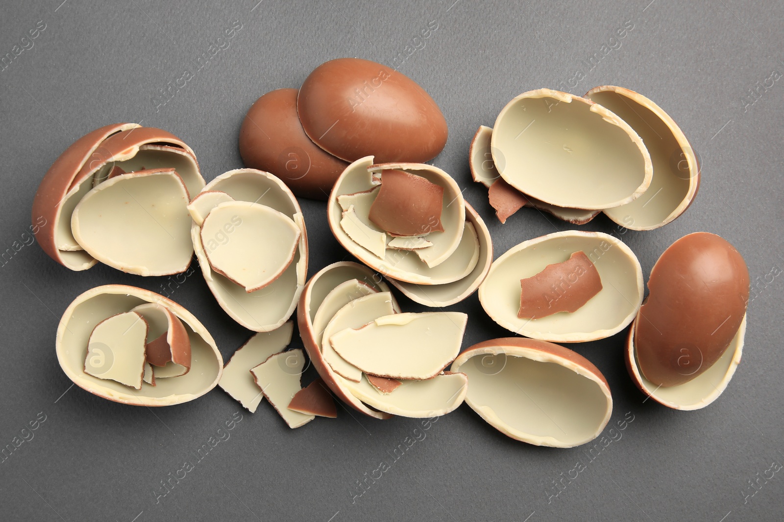 Photo of Sveti Vlas, Bulgaria - July 3, 2023: Broken halves of Kinder Surprise Eggs on grey background, flat lay