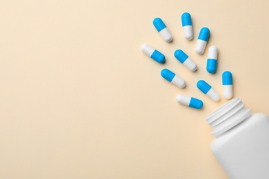Photo of Bottle with pills on color background, flat lay. Space for text