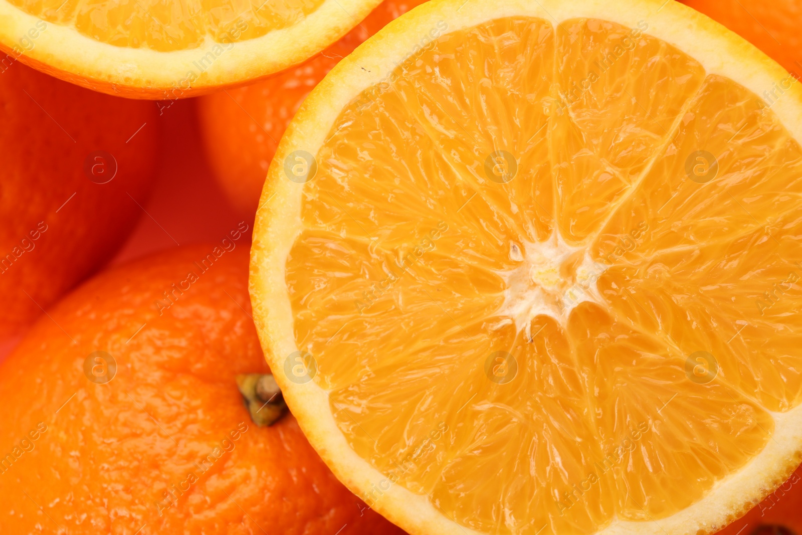 Photo of Cut and whole fresh ripe oranges as background, top view