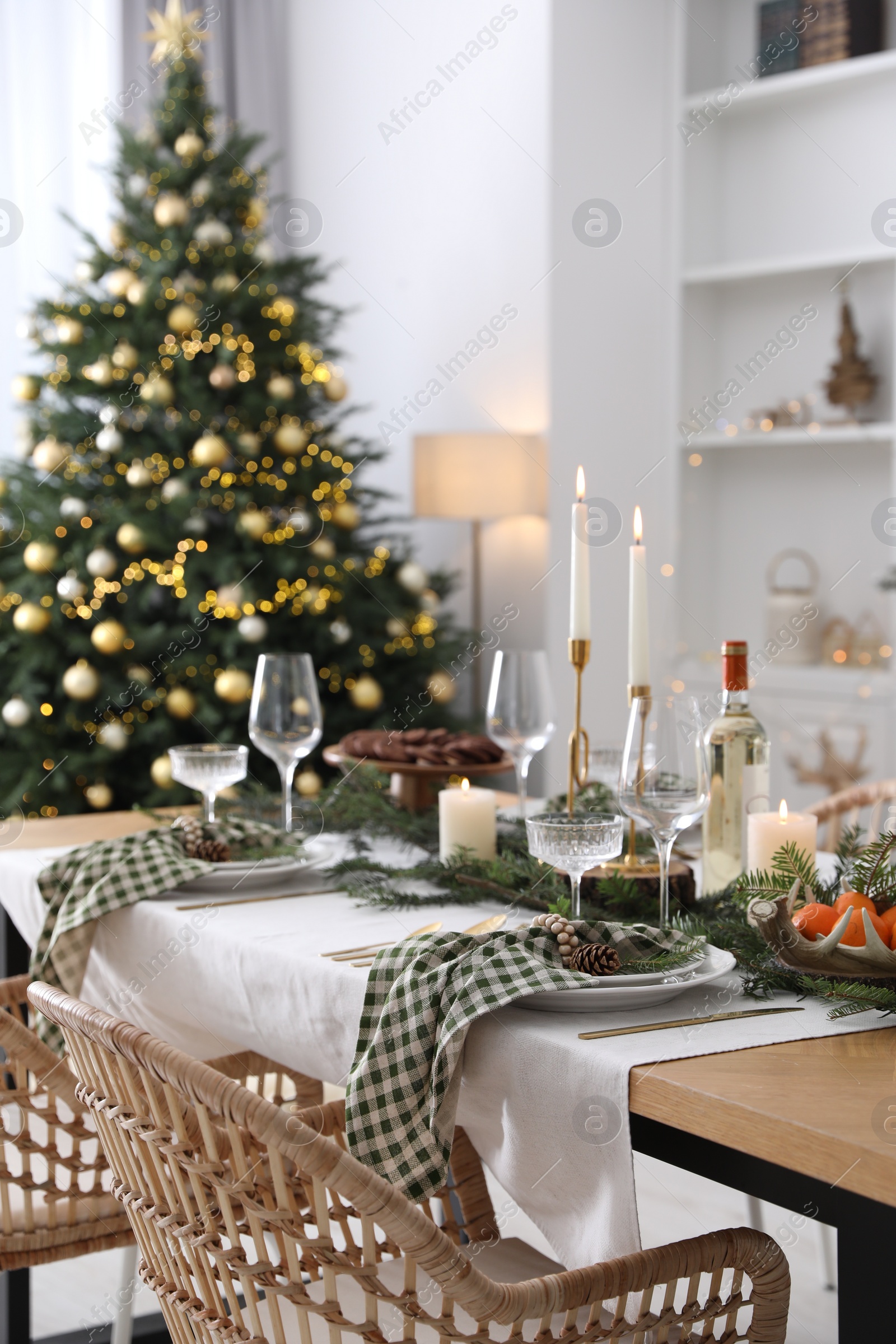 Photo of Christmas table setting with festive decor and dishware in room