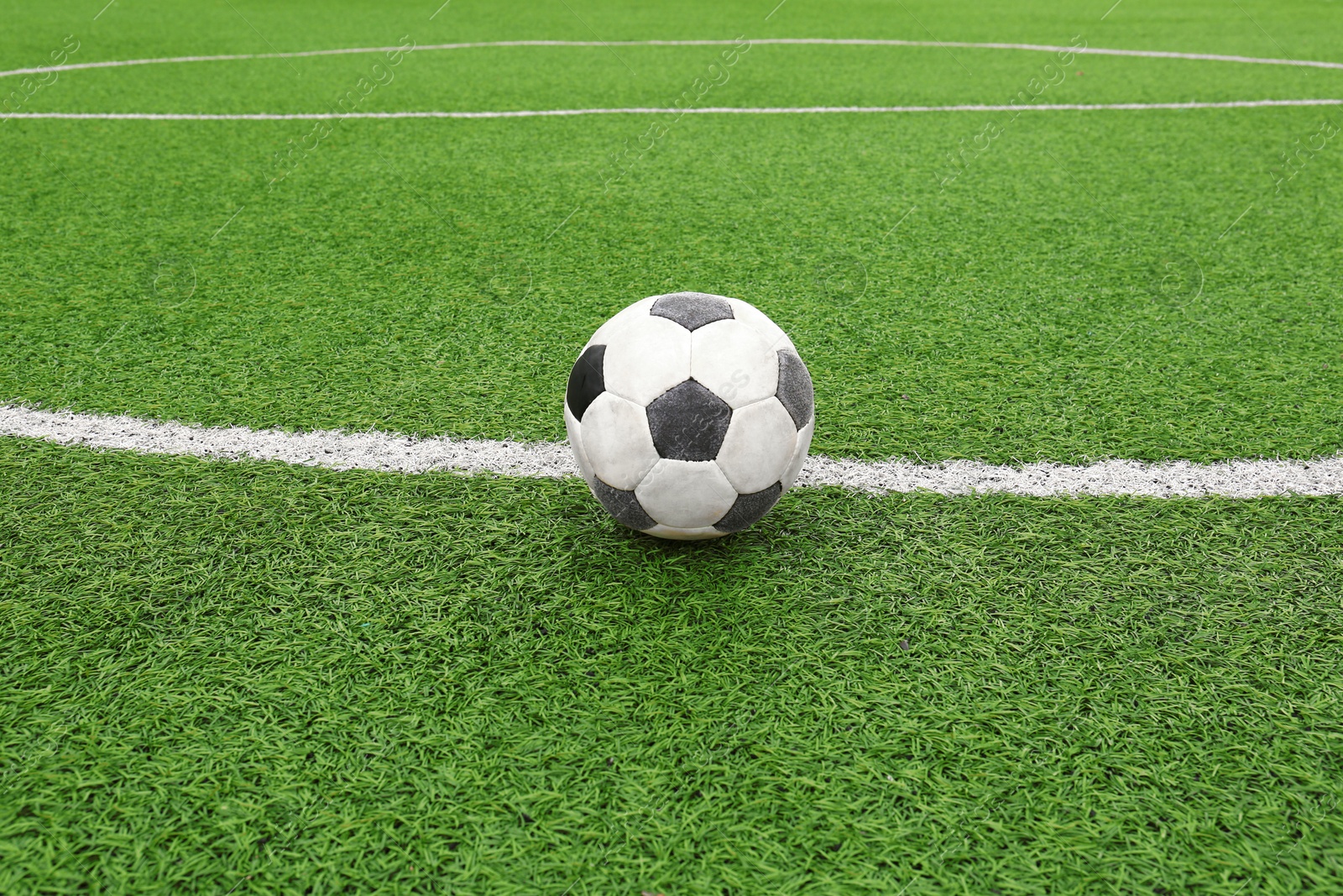 Photo of Dirty soccer ball on green football field