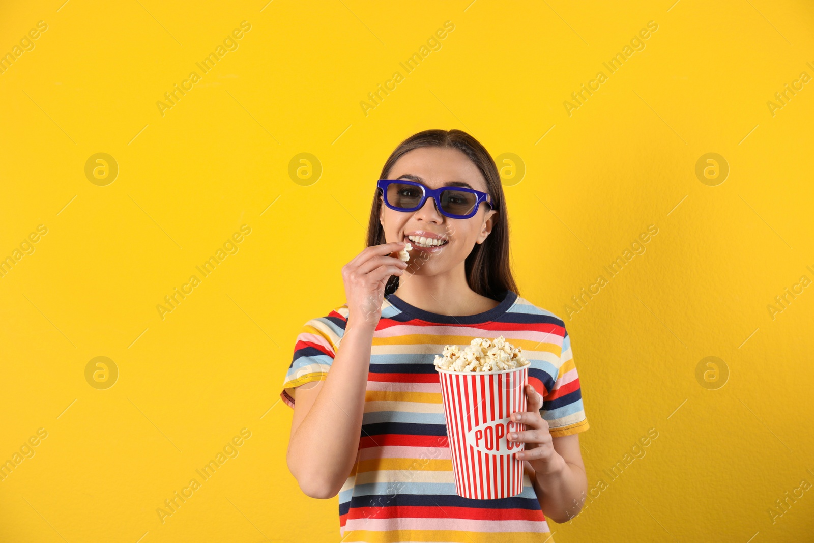 Photo of Young woman with 3D glasses and tasty popcorn on color background