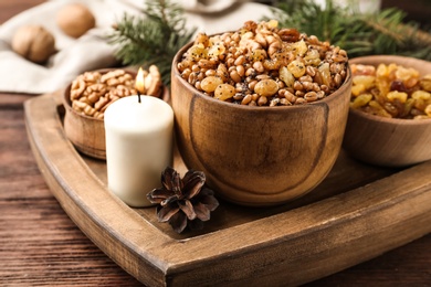 Traditional Christmas slavic dish kutia and burning candle on wooden table, closeup