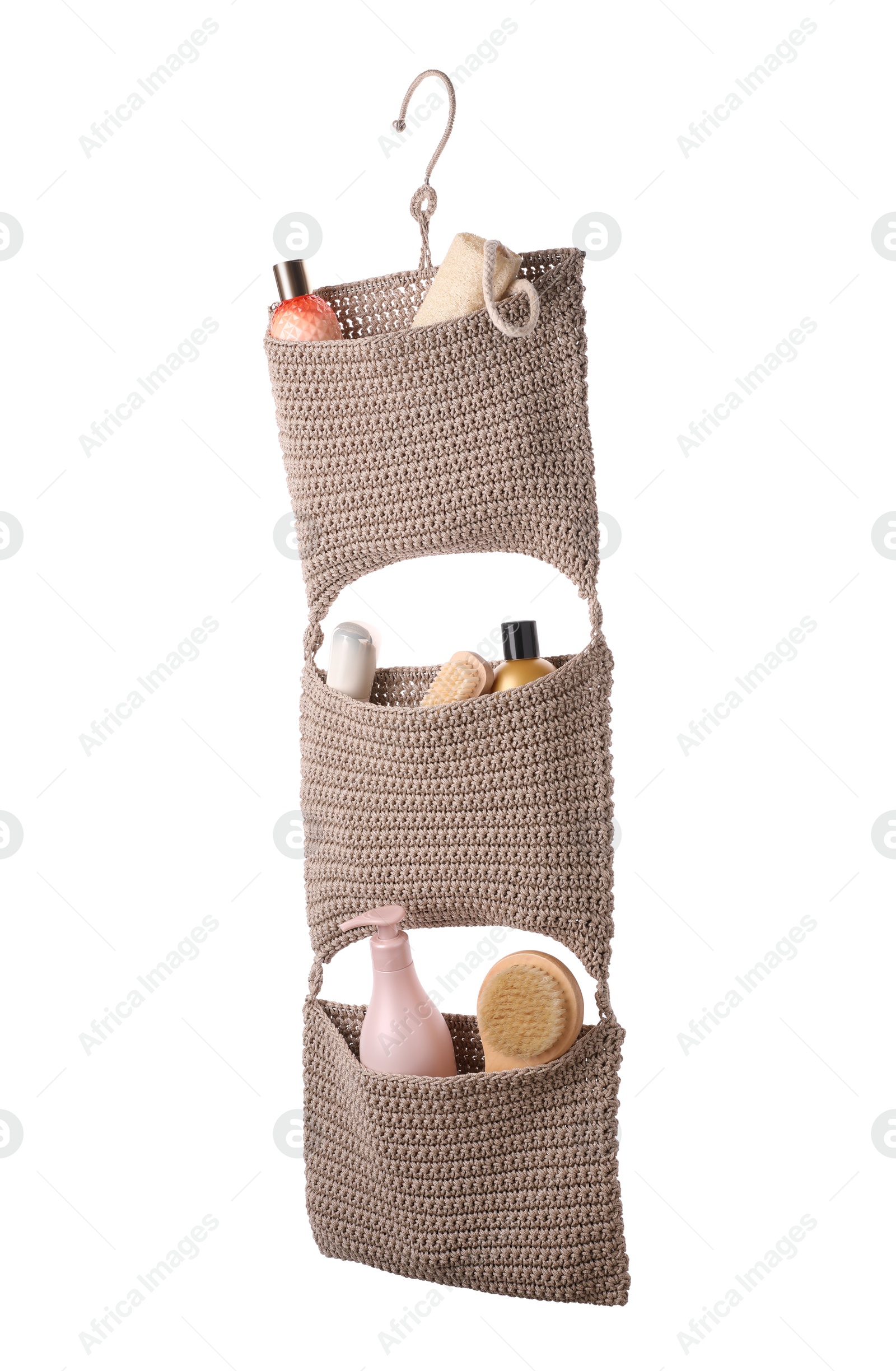 Photo of Stylish knitted organizer with toiletries and brushes on white background. Bath accessory