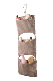 Stylish knitted organizer with toiletries and brushes on white background. Bath accessory