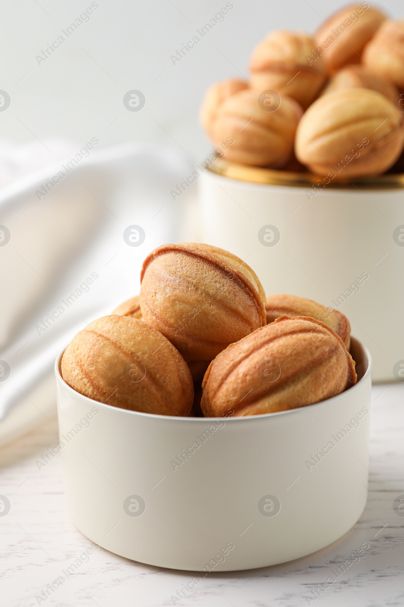 Photo of Delicious nut shaped cookies on white wooden table