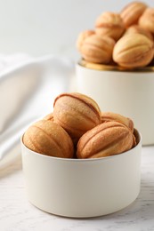 Photo of Delicious nut shaped cookies on white wooden table