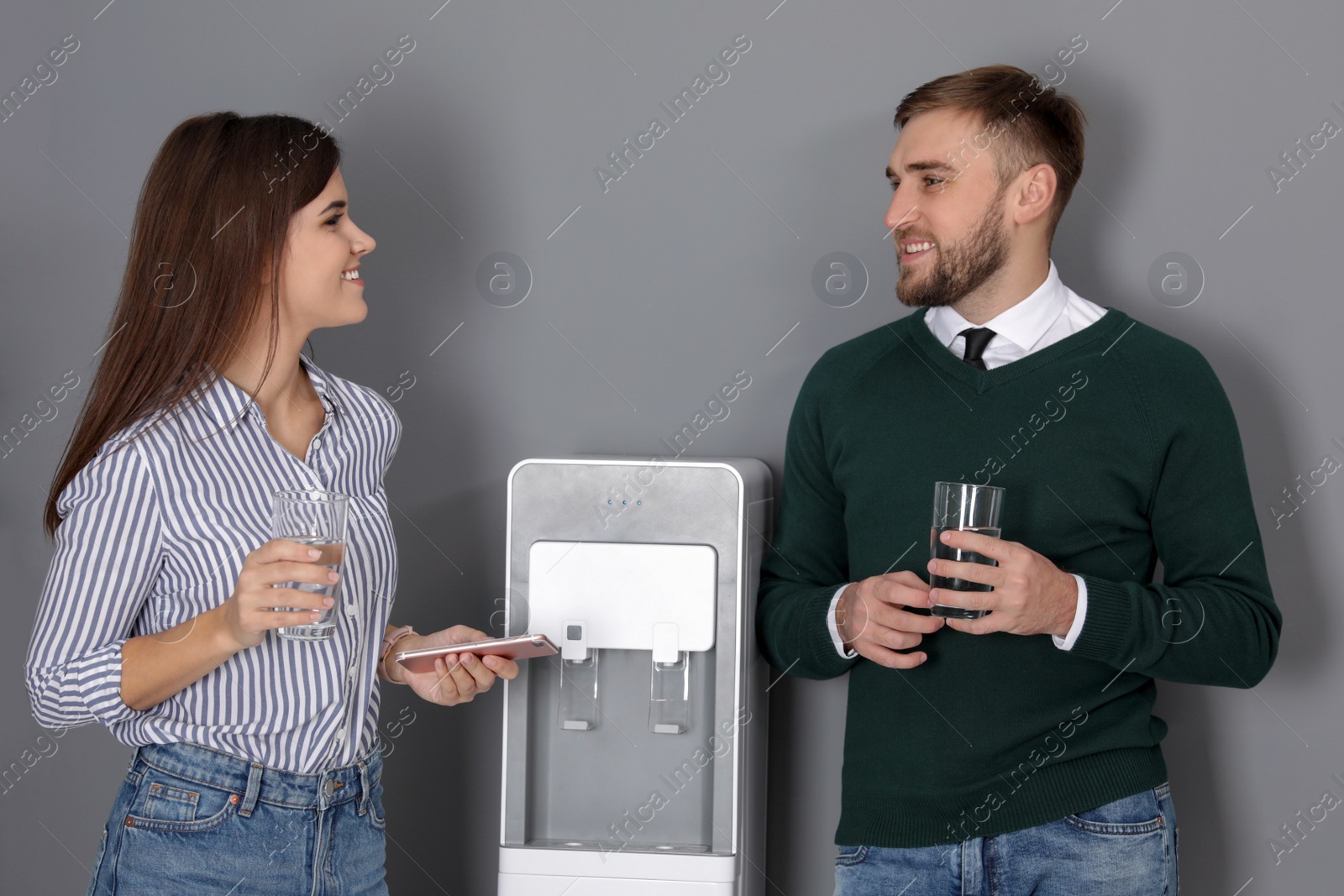 Photo of Employees having break near water cooler in office