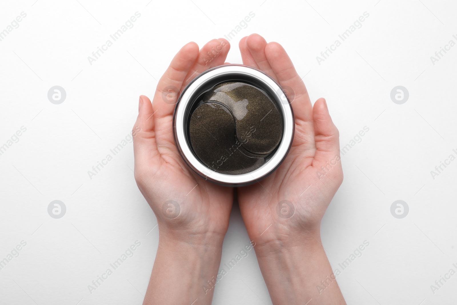 Photo of Woman holding jar with under eye patches on white background, top view. Cosmetic product