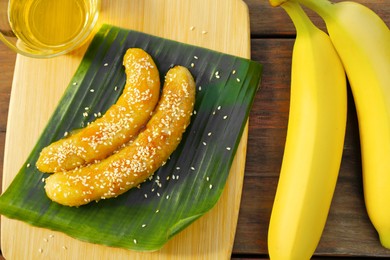 Delicious fresh and fried bananas with oil on wooden table, closeup