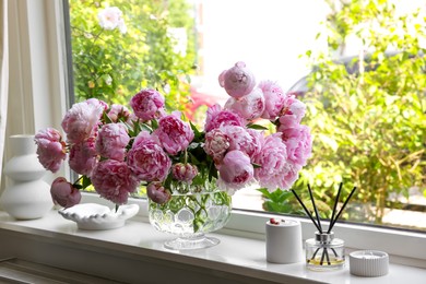 Photo of Beautiful pink peonies in vase on window sill. Interior design