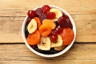 Photo of Mix of delicious dried fruits on wooden table, top view