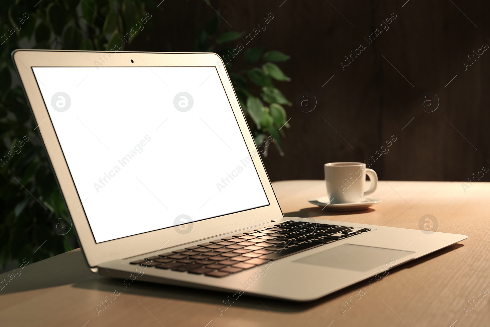 Photo of Modern laptop and cup of coffee on desk in office. Space for design