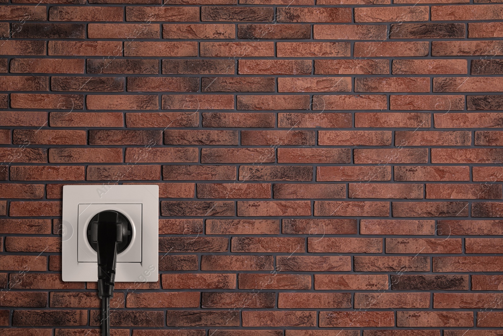 Brick wall with power socket and inserted plug, space for text. Electrical supply Image of Brick wall with power socket and inserted plug, space for text. Electrical supply