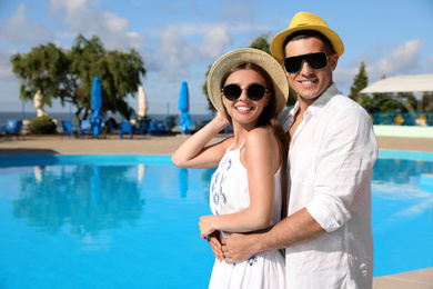 Photo of Happy couple near swimming pool. Summer vacation