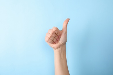 Photo of Woman showing number ten on color background, closeup. Sign language