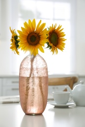 Bouquet of beautiful sunflowers on table in kitchen