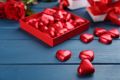 Heart shaped chocolate candies on blue wooden table