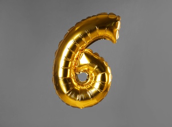 Photo of Golden number six balloon on grey background