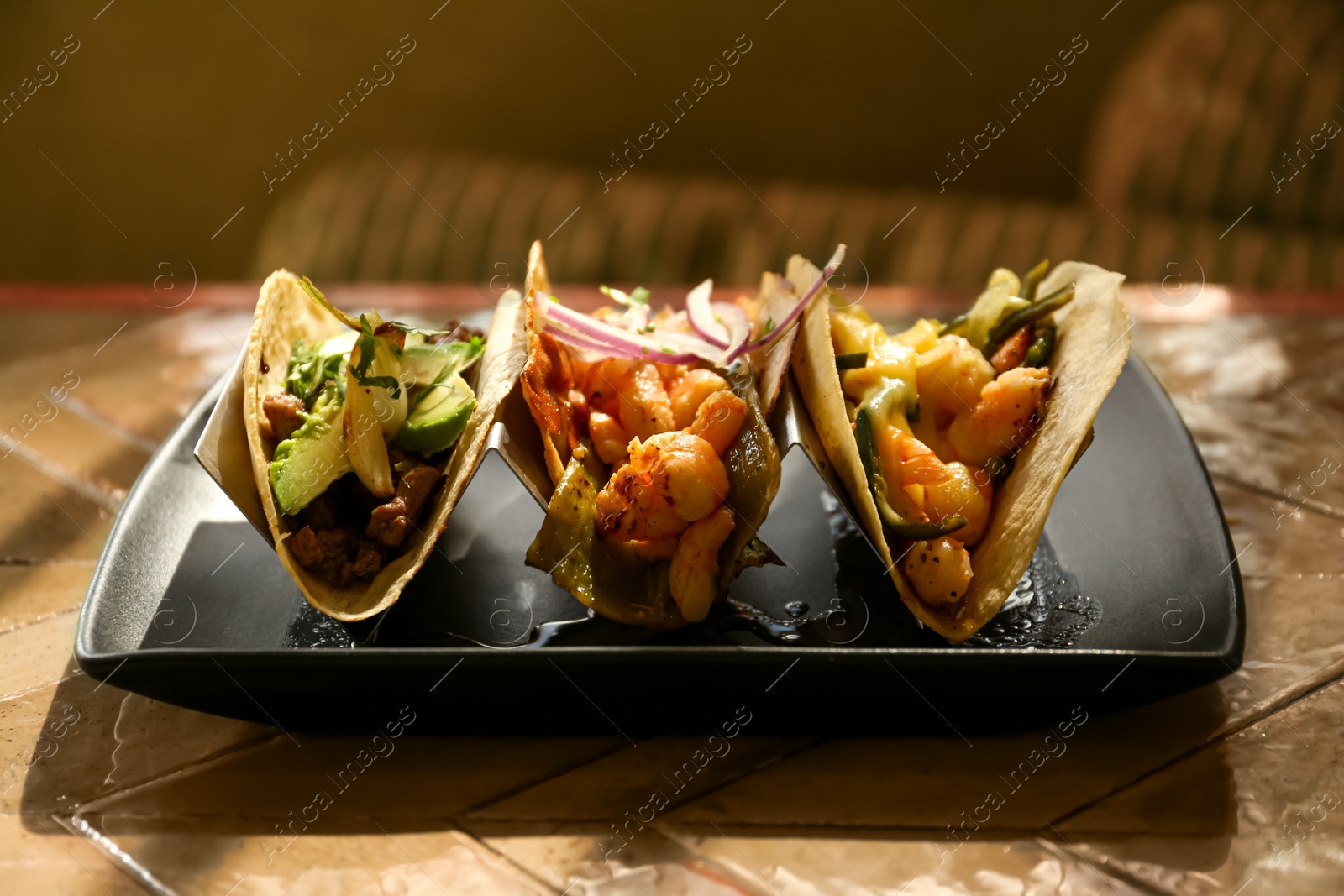 Photo of Delicious tacos with shrimps and vegetables on table