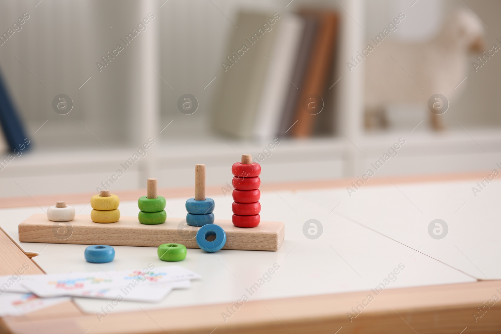 Photo of Stacking and counting game on table indoors, space for text. Educational toy for motor skills development