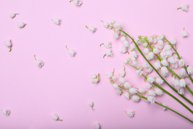 Photo of Beautiful lily of the valley flowers on pink background, flat lay