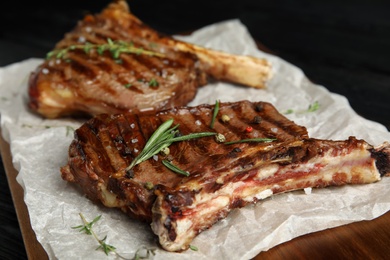 Photo of Tasty grilled meat steaks on board, closeup
