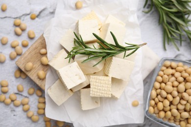 Delicious tofu cheese, rosemary and soybeans on light gray textured table, flat lay