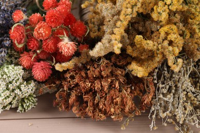 Photo of Different medicinal herbs on wooden table, closeup