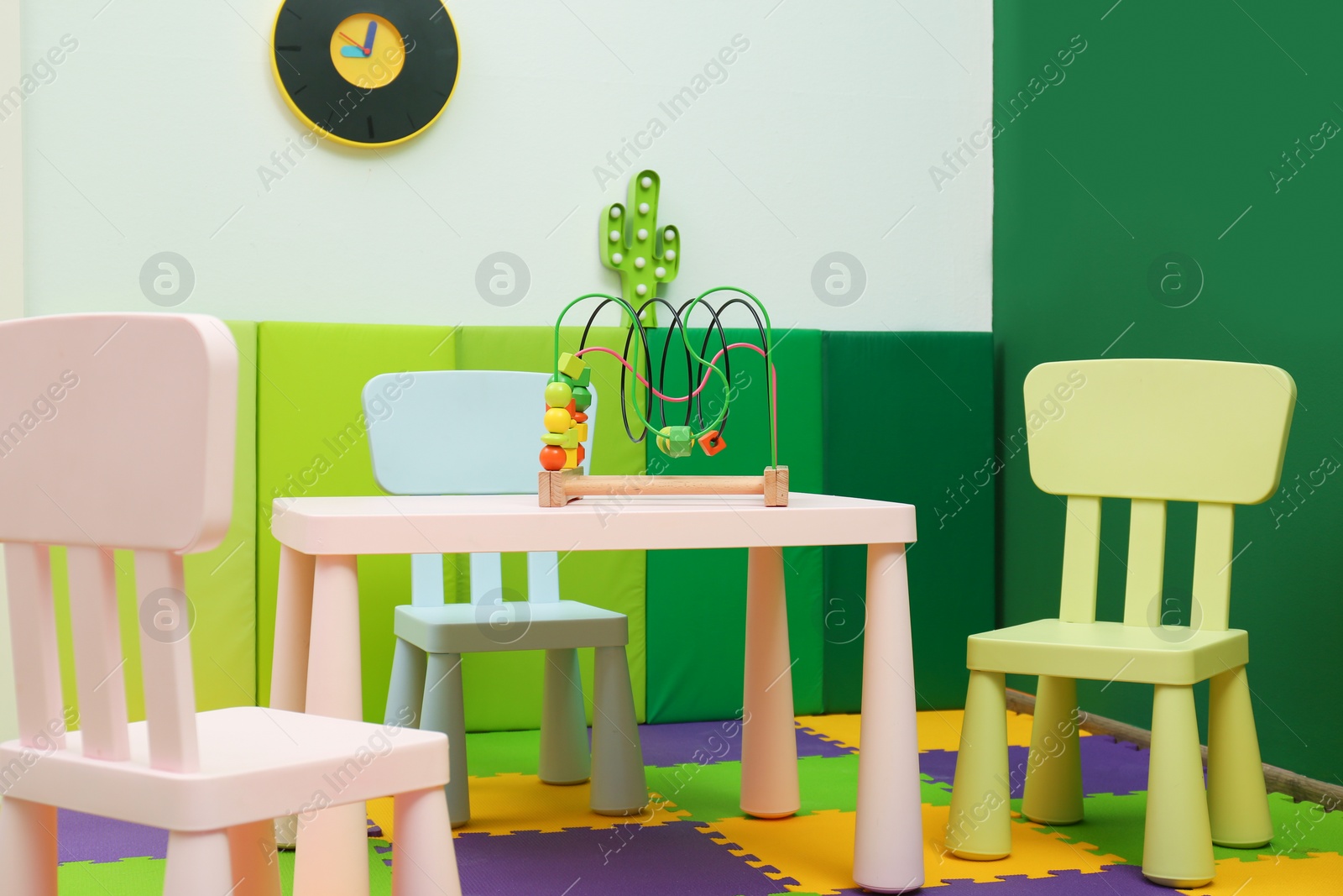 Photo of Stylish playroom interior with table and chairs