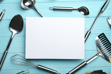 Photo of Flat lay composition with different kitchen utensils and empty card on color background, space for text