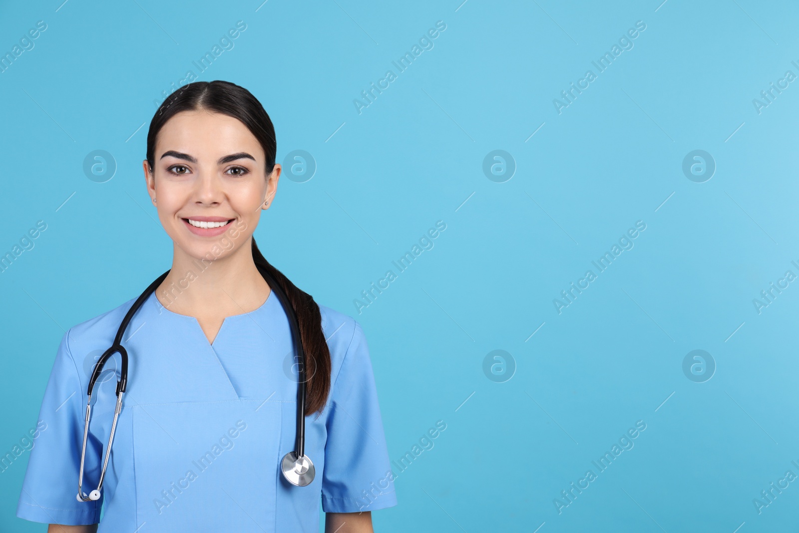 Photo of Portrait of medical assistant with stethoscope on color background. Space for text