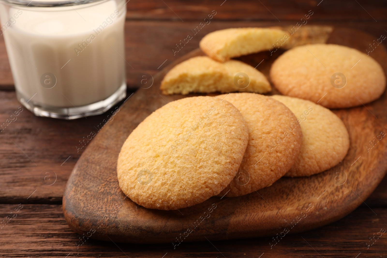 Photo of Delicious Danish butter cookies and milk on wooden table, closeup