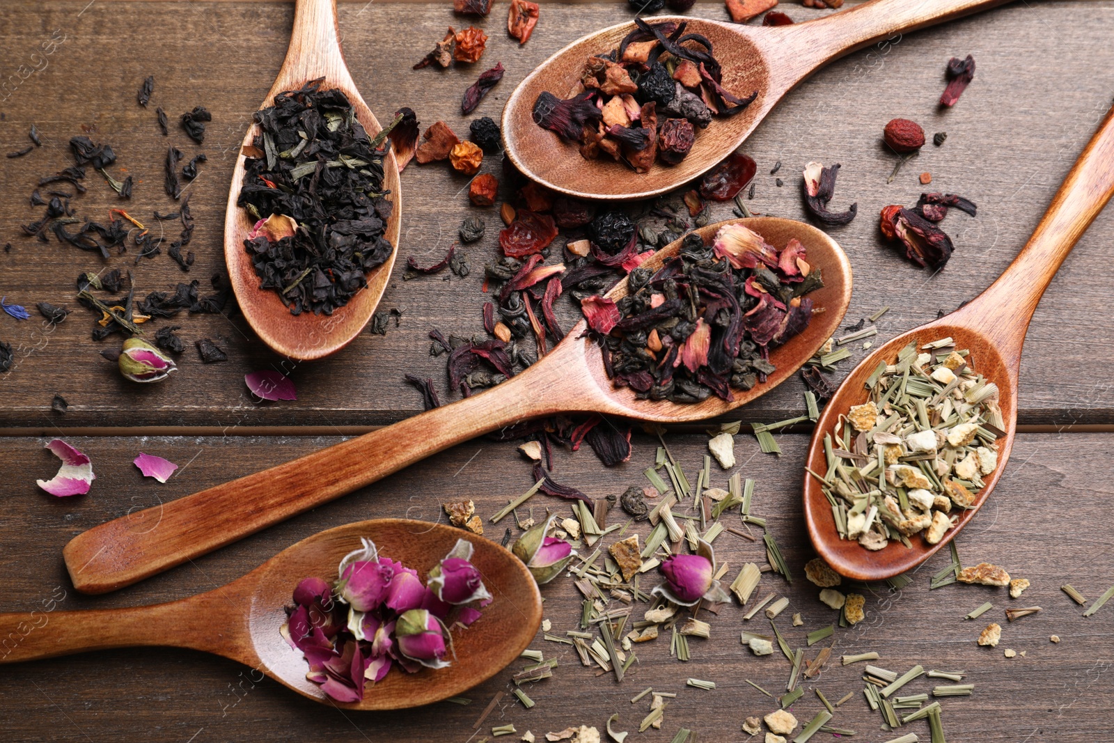 Photo of Flat lay composition with different teas and spoons on wooden table