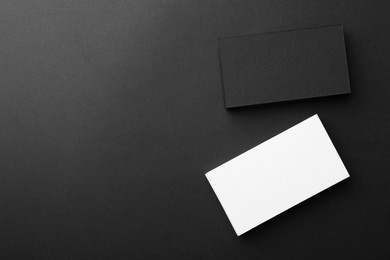 Photo of Blank business cards on black background, flat lay. Mockup for design