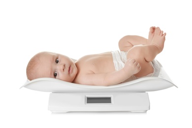 Photo of Cute little baby lying on scales against white background