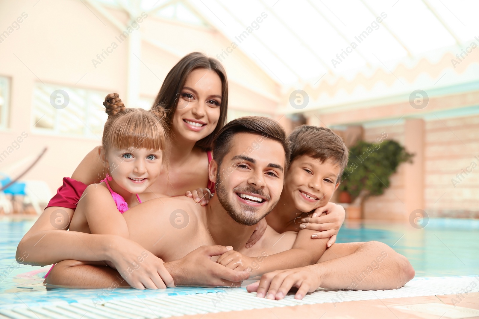 Photo of Happy family resting in indoor swimming pool