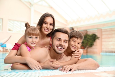 Photo of Happy family resting in indoor swimming pool