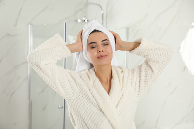 Photo of Young woman with hair wrapped in towel indoors