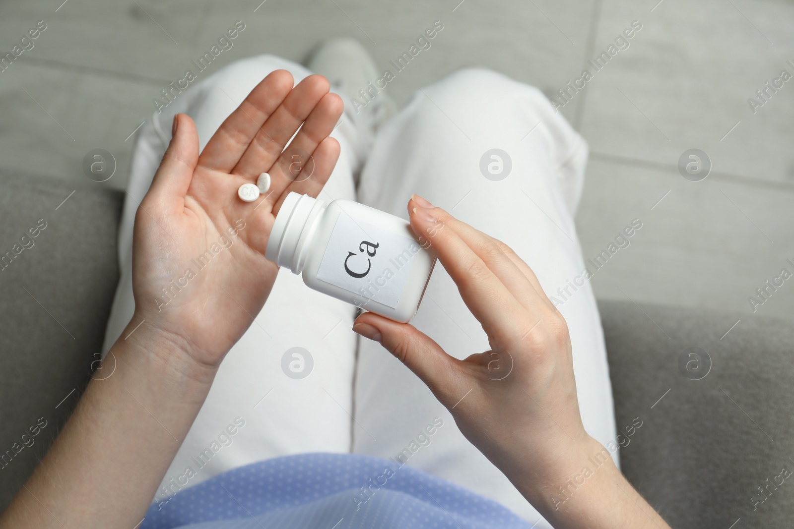 Photo of Calcium supplement. Woman taking pills indoors, top view